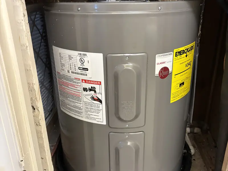 New electric tank water heater installed in a closet