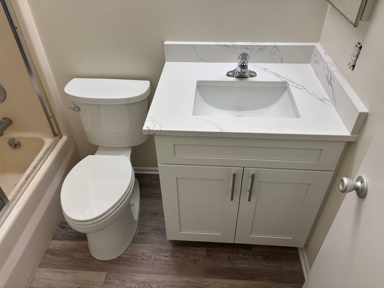 Bathroom vanity, toilet, and shower after fixture installation