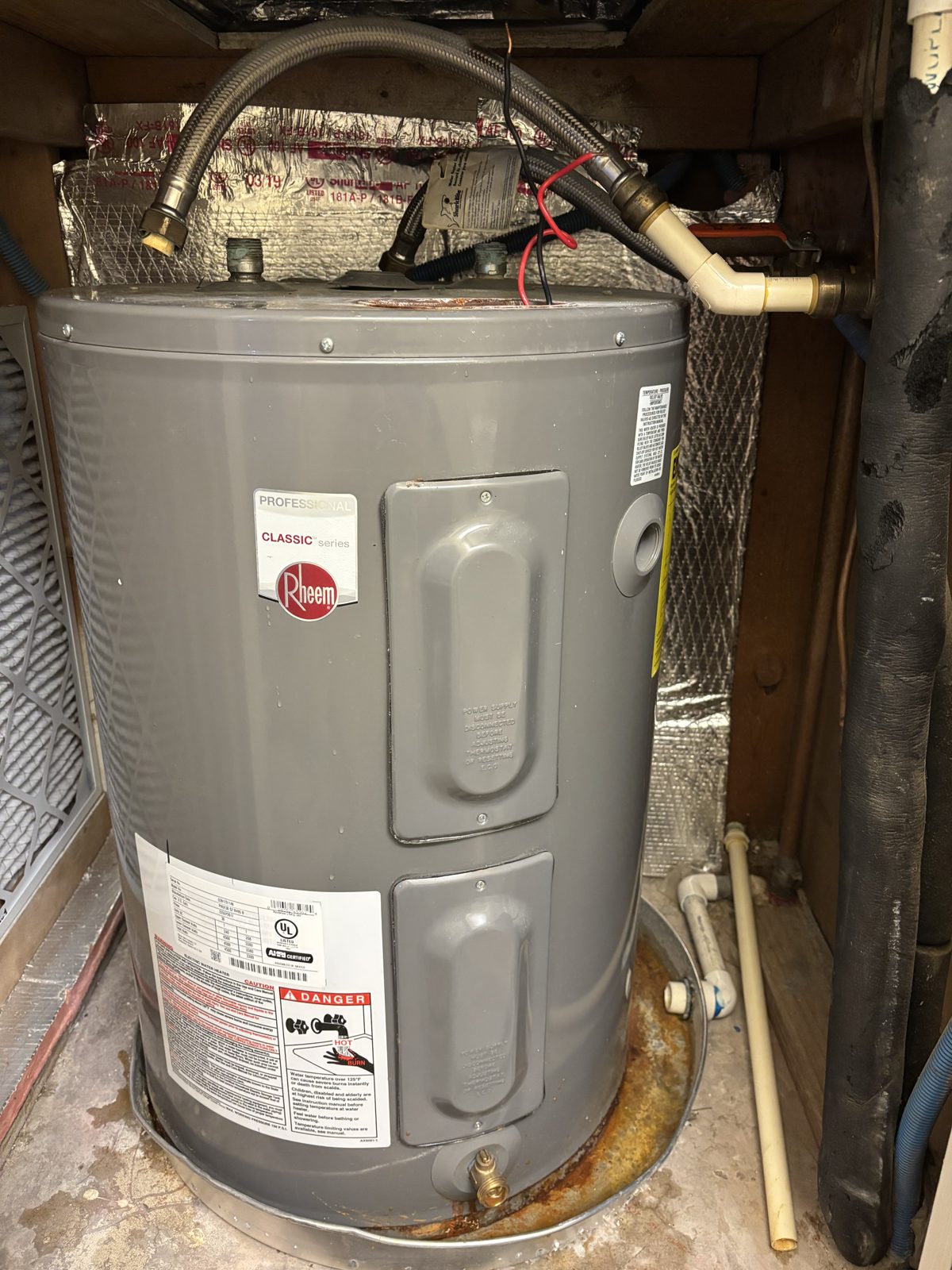 Installed tank water heater with copper and dielectric fittings